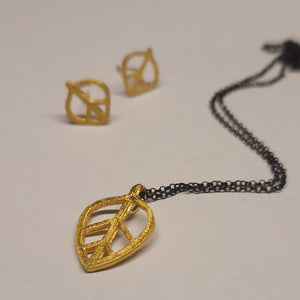 Gold necklace and earrings on a light gray background