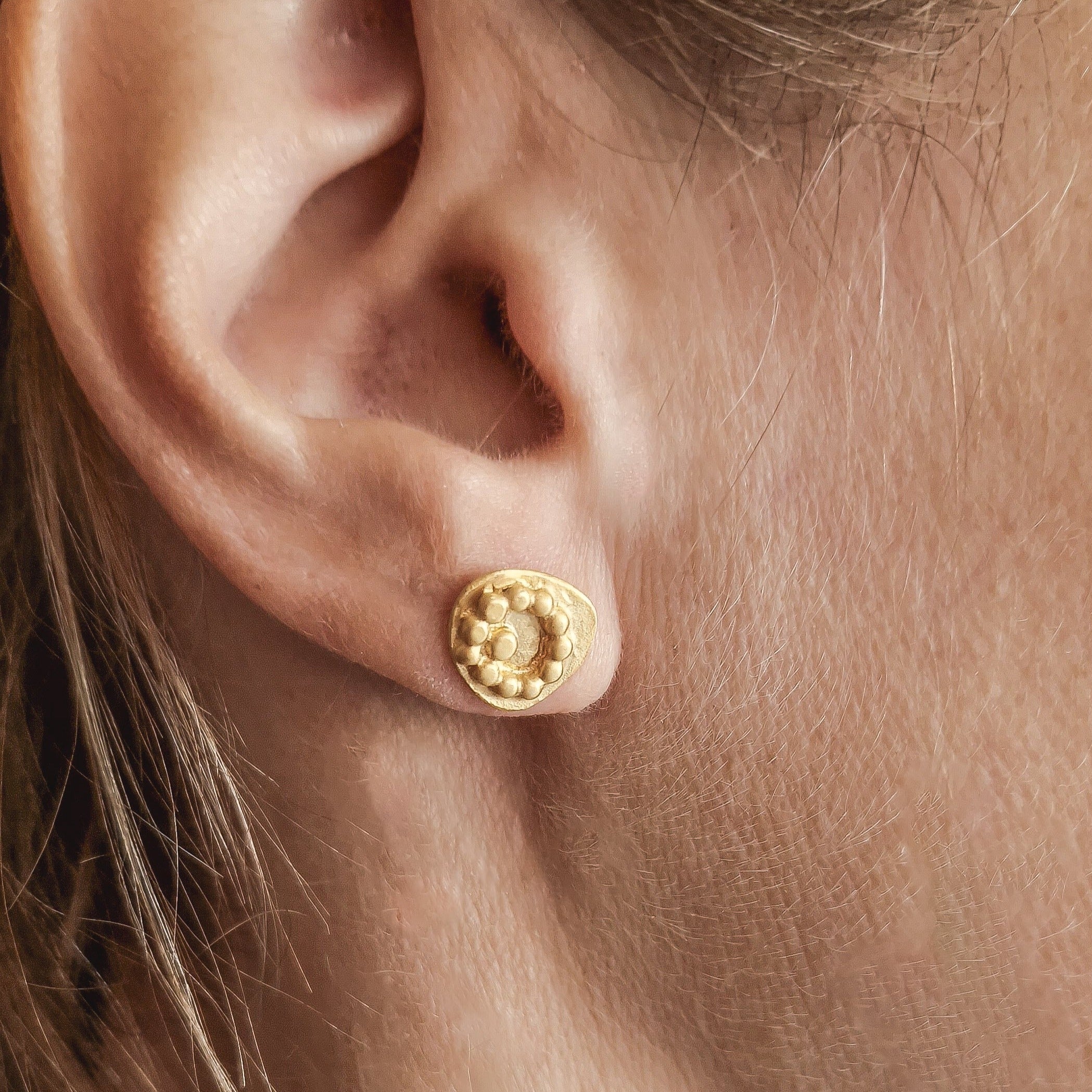 Gold dots stud earrings. The jewelry is made from 925 sterling silver and has been gold-plated to create an exquisite piece. A series of dots arranged in a modern and contemporary style makes this design perfect for everyday wear. With its simple design, it can be paired with any outfit, adding a touch of elegance to your look. 