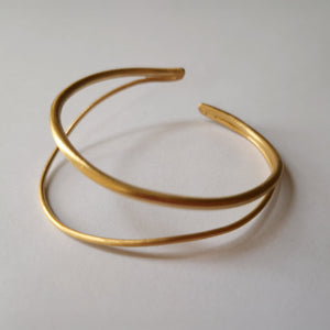 Gold bracelet on a light gray background