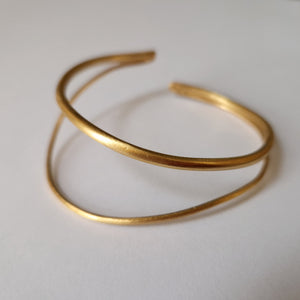 Gold bracelet on a light gray background
