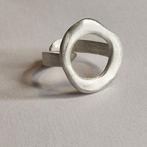 Silver ring with a unique design on a light gray background