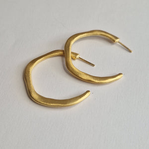 Gold hoop earrings on a light gray background
