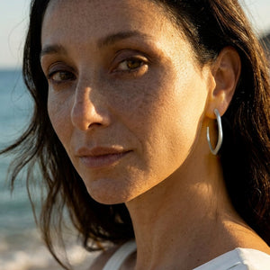 Woman with hoop earrings on a beach