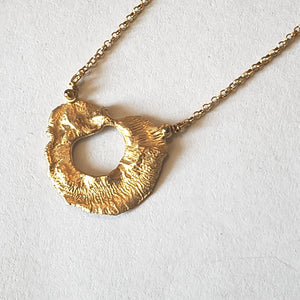 Close-up of VOLCANO textured matte gold plated sterling silver pendant