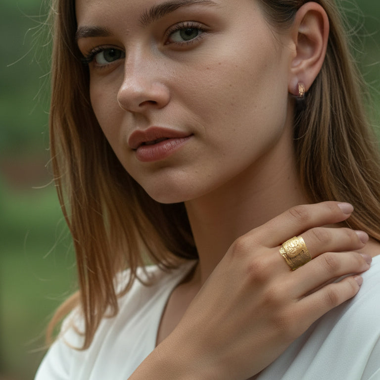 Woman wearing a gold ring with a blurred natural background